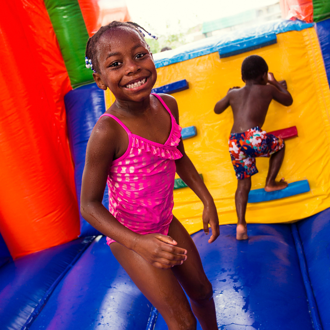 Dual lane water slide rental with children sliding down at a summer party in Valdosta, Georgia
